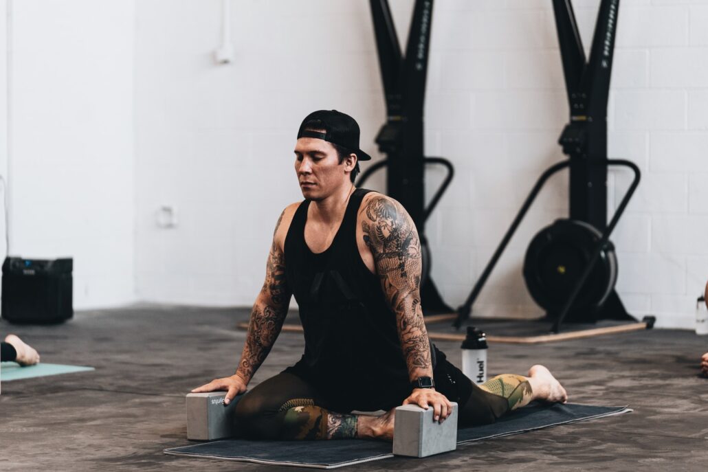 woman in black tank top and black pants sitting on black wooden table