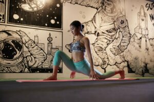 woman doing yoga beside mural wall